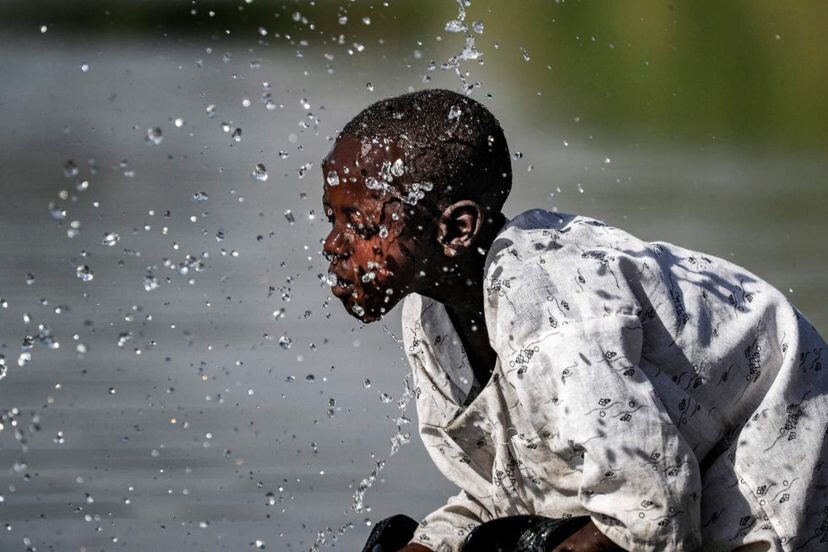 Un niño se salpica con agua en el río Atbarah cerca de la aldea de Dukouli, en la región agrícola de Fashaqa al-Sughra, en el este de Sudán, el 16 de marzo de 2021.ASHRAF SHAZLY / AFP