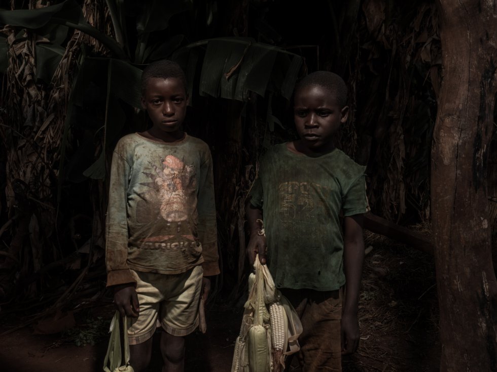 Dos niños de Sanga vuelven del campo cargados de maíz.rnrnrn