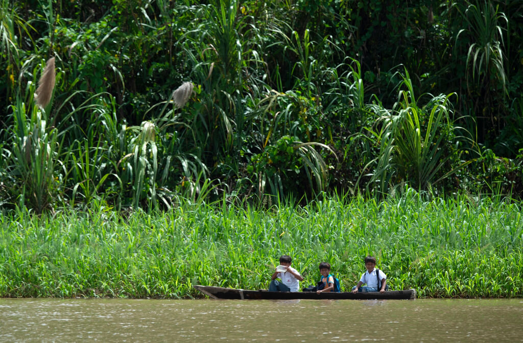 Los niños van a la escuela en canoa por el río Maranon, uno de los principales afluentes del río Amazonas, en la Reserva Nacional Pacaya Samiria, el 24 de mayo de 2019. (CRIS BOURONCLE/AFP/Getty Images)