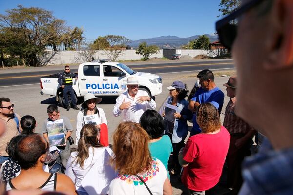 En el medio del círculo de personas, se observa al exdiputado Edgardo Araya dirigirse a los vecinos que participaron de la manifestación, mientras que una patrulla de la Fuerza Pública observa sin intervenir. Foto: Albert Marín